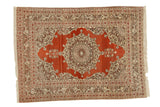 Antique Haji Jalili Tabriz rug with an ornate medallion on a rust field and a complex silvery bronze border.