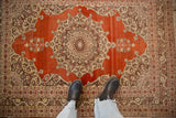 Looking down at the antique Haji Jalili rug's intricate medallion and silvery bronze border.