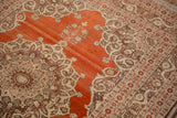 Ornate medallion corner and silvery bronze border detail on a rust-red antique Haji Jalili Tabriz rug.