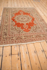 Angled view of an antique Haji Jalili Tabriz rug showing its full length, rust-red medallion, and detailed borders.