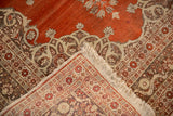 Folded corner of an antique Tabriz rug showing its finely woven foundation and red-rust pile.