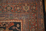 Corner detail of the vintage Mahal carpet's classic turtle samovar border in rust, green, and navy.