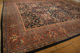 A vintage Mahal carpet's corner showing the terracotta rust border with turtle samovar designs.