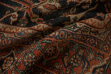 Soft folds of a vintage Mahal carpet showing its low pile and intricate navy and rust design.