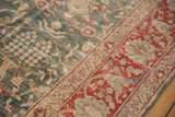 Distressed low pile texture on a vintage Tabriz corner showing forest green and cherry red floral patterns.