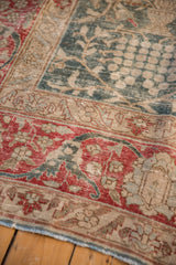 Detail of the worn, textured pile on the red border and green lattice field of a distressed Tabriz rug.