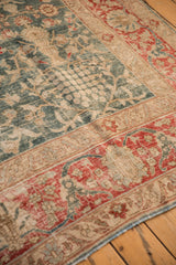 Worn low pile of a distressed Tabriz rug with cherry red and forest green floral motifs.