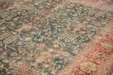Angled view of the distressed, low-pile texture on a vintage Persian Tabriz carpet.