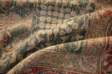 A close-up showing the distressed, low pile texture on a vintage Tabriz rug in forest green and sand.