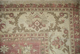Detail of the distressed Amritsar rug's corner, showing mostly even wear and serrated motifs.