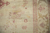 Worn pile texture and knot heads on a distressed Amritsar carpet with dusty red geometric motifs.