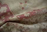 Soft folds reveal the time-softened low pile and raspberry palmettes on a vintage Amritsar rug.