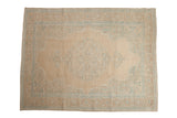 Vintage distressed Birjand carpet with a central medallion design in muted sand, ivory, and powder blue.