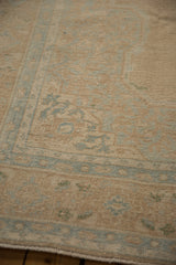 Close-up of the distressed, low pile texture on a vintage Persian carpet in sand and powder blue.