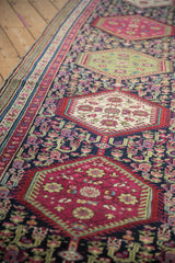 Antique Karabagh runner's ivory medallion with quatrefoil blossoms and delicate vines on a navy ground.