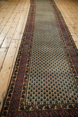 Vintage Afghani rug's lattice field of ivory, red, and teal blossoms next to a geometric border.