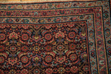 Corner view of a vintage Engelas rug with its navy Herati field and complex vine and boteh border.