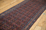 Angled perspective along the length of the vintage runner, detailing the Herati field and vine borders.