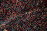 Angled view revealing the dense pile and rich navy and red Herati motifs.