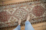 Distressed Serab runner with geometric medallion, finned plant motifs, and pawn border.
