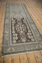 Distressed Malayer rug runner's heavily abrashed chocolate brown field and ivory, powder blue motifs.