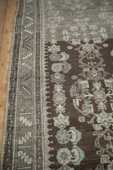 Distressed Malayer runner showing geometric border, chocolate brown field, and faded motifs.