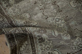 Distressed Malayer rug pile showing even wear, a serrated leaf border, and abrashed ground.