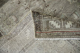 Vintage distressed Malayer rug's hand-knotted foundation and muted geometric border detail.