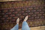 Overhead perspective of the vintage Qashqai rug's multi-columned design and saffron border.