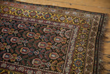 Vintage Qashqai runner corner with saffron gold borders, geometric motifs, and dark fringe.
