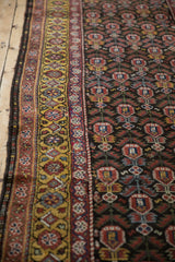 Detail of the saffron gold border and chocolate brown field of a vintage Qashqai rug runner.