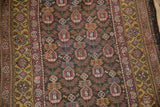 The repeating germinating plant design and saffron gold border on a low-pile vintage Qashqai rug.