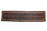 Vintage Northwest Persian runner, indigo field of detailed bird and plant motifs, ivory serrated border.