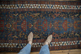Vintage Northwest Persian runner with indigo field, potted plants, birds, and serrated border.