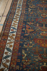 Hand-knotted Northwest Persian runner detail: ivory serrated leaf border and navy field with potted plant vines.