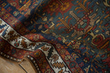 Textured vintage Persian runner with navy field patterns, tangerine hues, and ivory serrated border.
