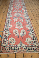 Vintage distressed Arak runner detail: faded cherry field, ivory floral sprays, navy border, knot head wear.