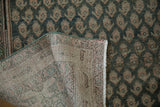 Distressed Malayer rug showing worn teal, ivory botehs and woven foundation.