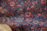 Hand-knotted vintage Tabriz rug featuring rich Herati design in navy blue and cherry red.