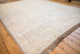 Distressed Afghani Oushak carpet corner with intact side cord selvage and subtle hues.
