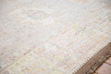 Distressed Afghani Oushak rug pile texture, with faded palmettes and intact side selvage.