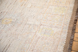 Distressed Afghani Oushak rug pile showing foundation, worn knot heads, and side selvage.