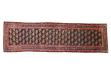 Antique Persian runner with allover floral bouquets in staggered rows against a deep navy blue background.
