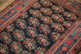 The traditional multi-layered border and navy floral field of an antique Northwest Persian runner.