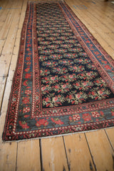 A long antique Persian runner seen from an angle, highlighting its floral lattice design.