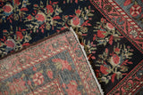 View of the antique Persian runner's hand-knotted foundation alongside its floral wool pile.