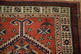 Geometric borders with crab-style forms on the hand-knotted pile of a vintage Persian Serab runner.