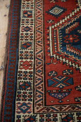 Intricate geometric side borders in brick red, sapphire blue, and faded pink.