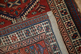 Folded corner of a vintage Serab runner reveals its secured side cord and woven foundation.