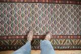 Looking down at the hand-knotted texture of a Persian runner's lattice-like shrub pattern.